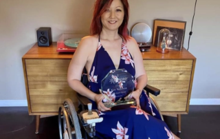 Woman in wheelchair holding award