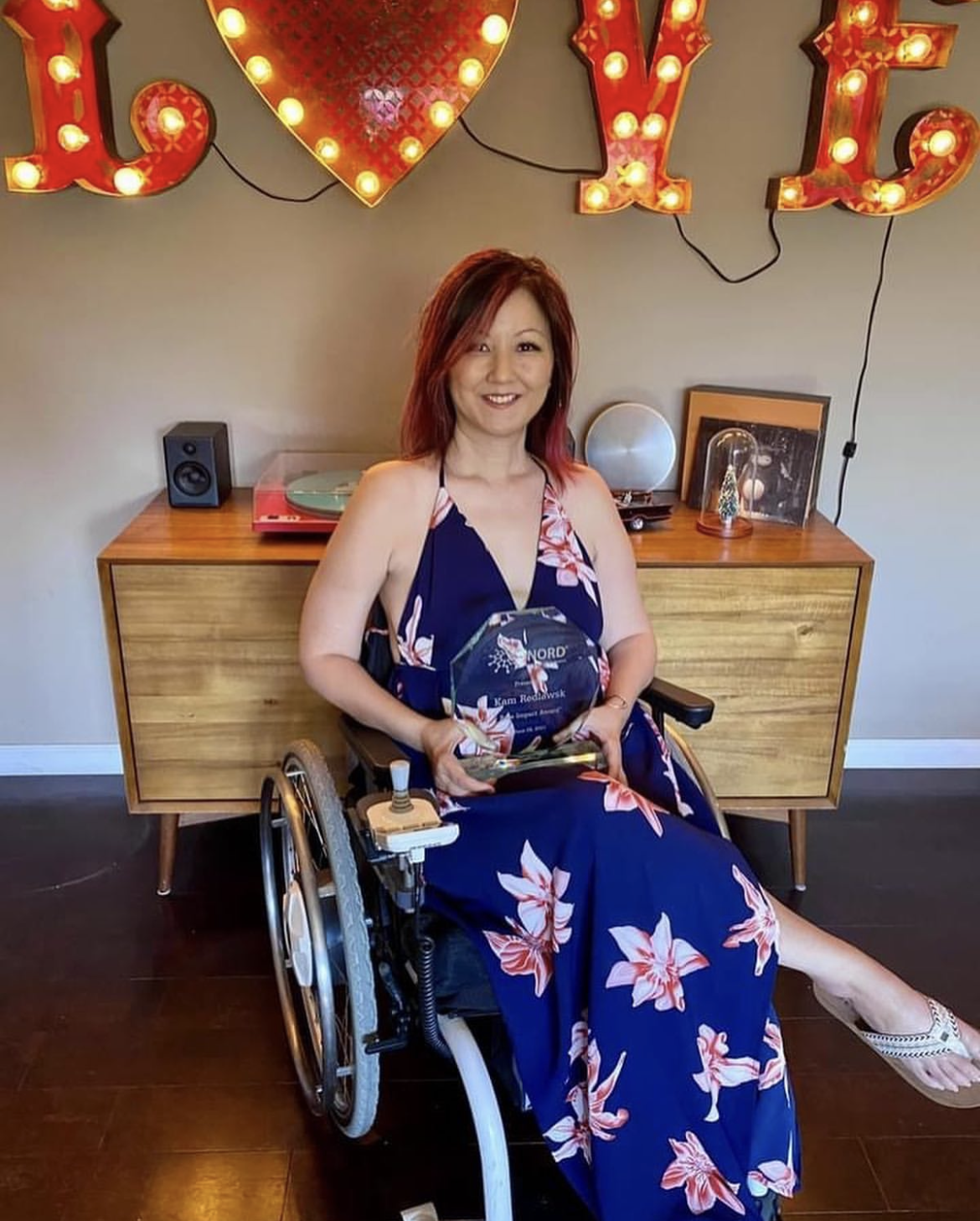 Woman in wheelchair holding award